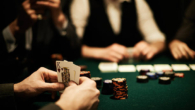 Hands of card player holding king of hearts