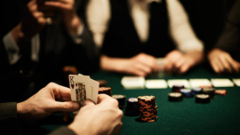 Hands of card player holding king of hearts