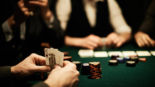 Hands of card player holding king of hearts
