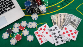 poker chips with banknotes placed on a laptop keyboard. Poker concept